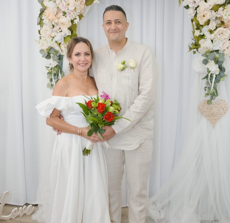 Bride & Groom at the Ceremony Suite Wedding by Iris Ramil Bride & groom stand together, surrounded by wedding arch at Ceremony Suite from Wedding Day Romance Miami